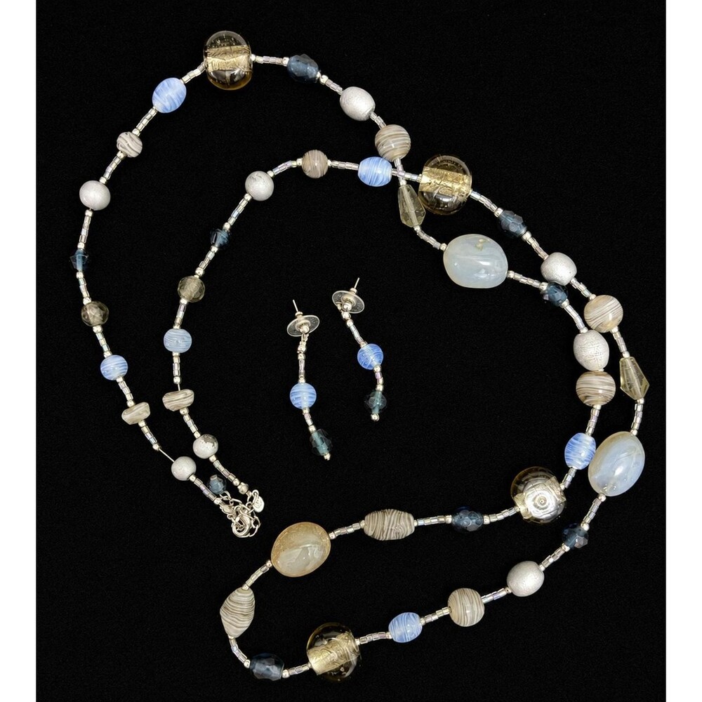 A dramatic 40-inch statement necklace featuring a rich mix of smoky gray, icy bl